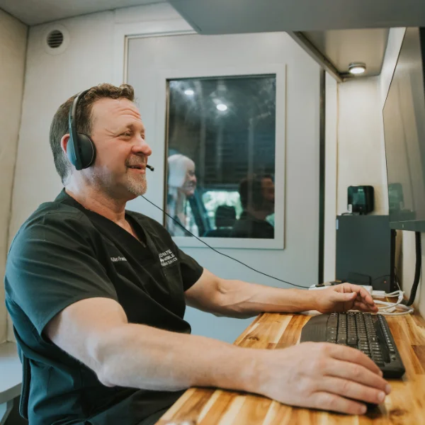 Allan performing a hearing test with computer equipment